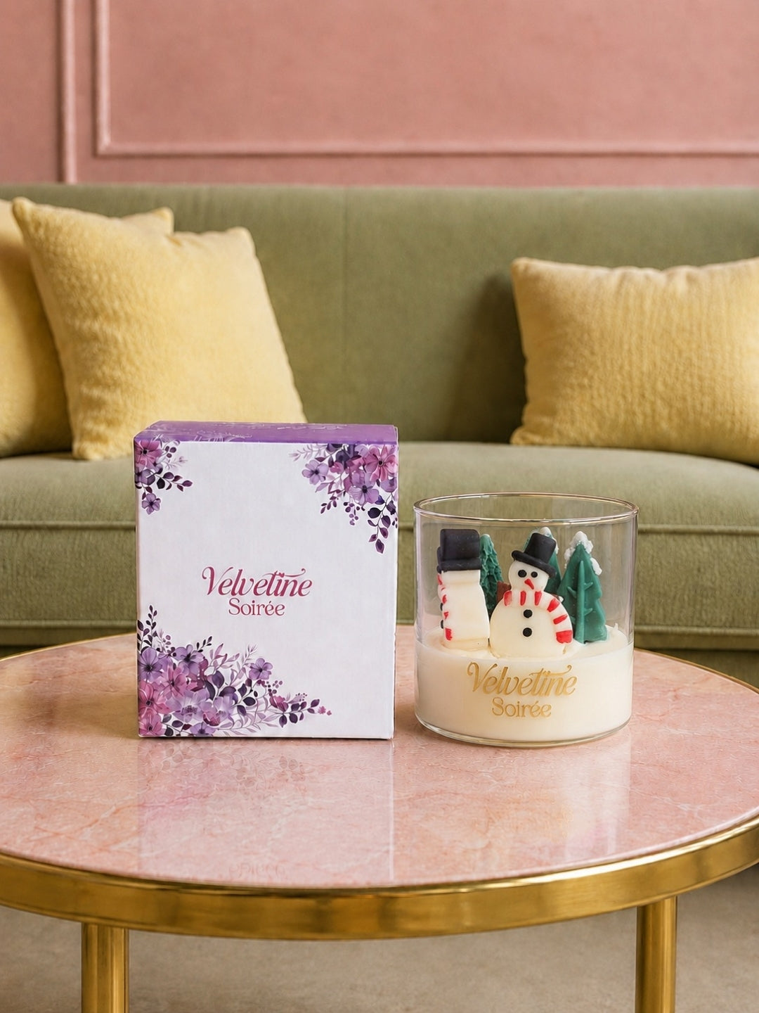 Frozen Wonder a candle jar with snowman and s-shaped wooden wick and patchouli scent. is lying on a table with luxury gift box