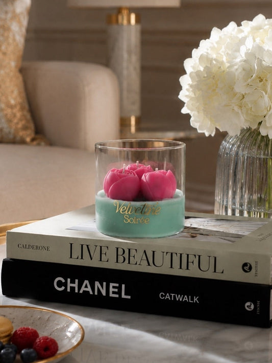 Tequila Sunrise Candle Jar on 2 books, it has 3 wicks and a floral fragrance that can fill the room