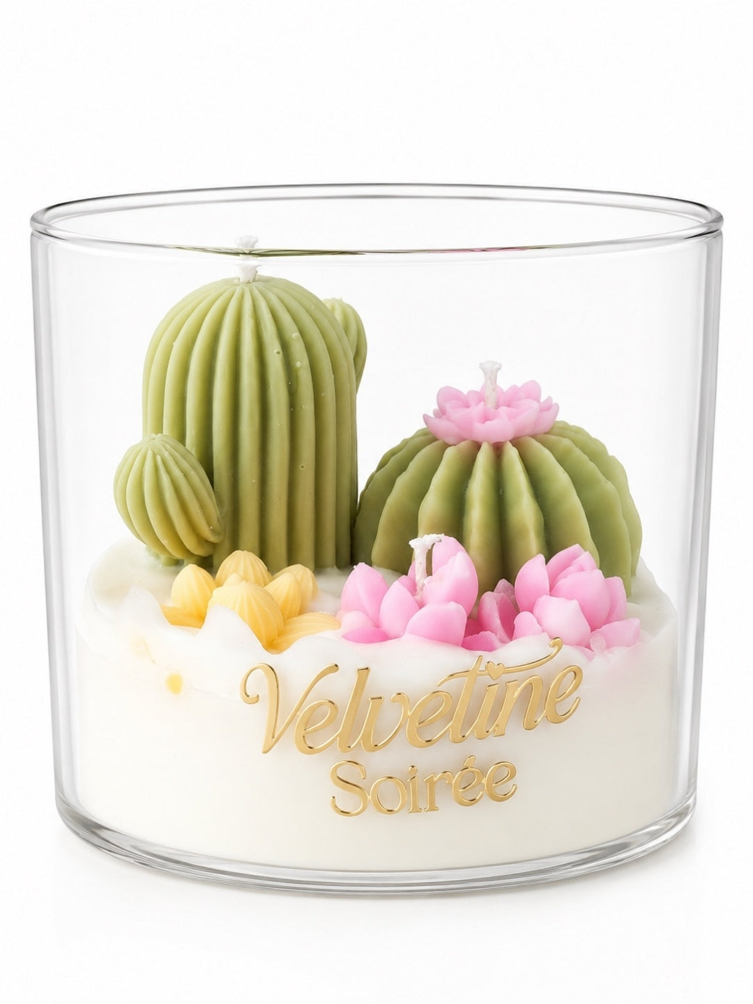 A clear glass jar candle labeled 'Velvetine Soirée' with a sculpted cactus and succulent design on top. The candle features olive green cacti, pink flowers, small yellow petals, and white wax base with gold lettering, set against a plain white background.