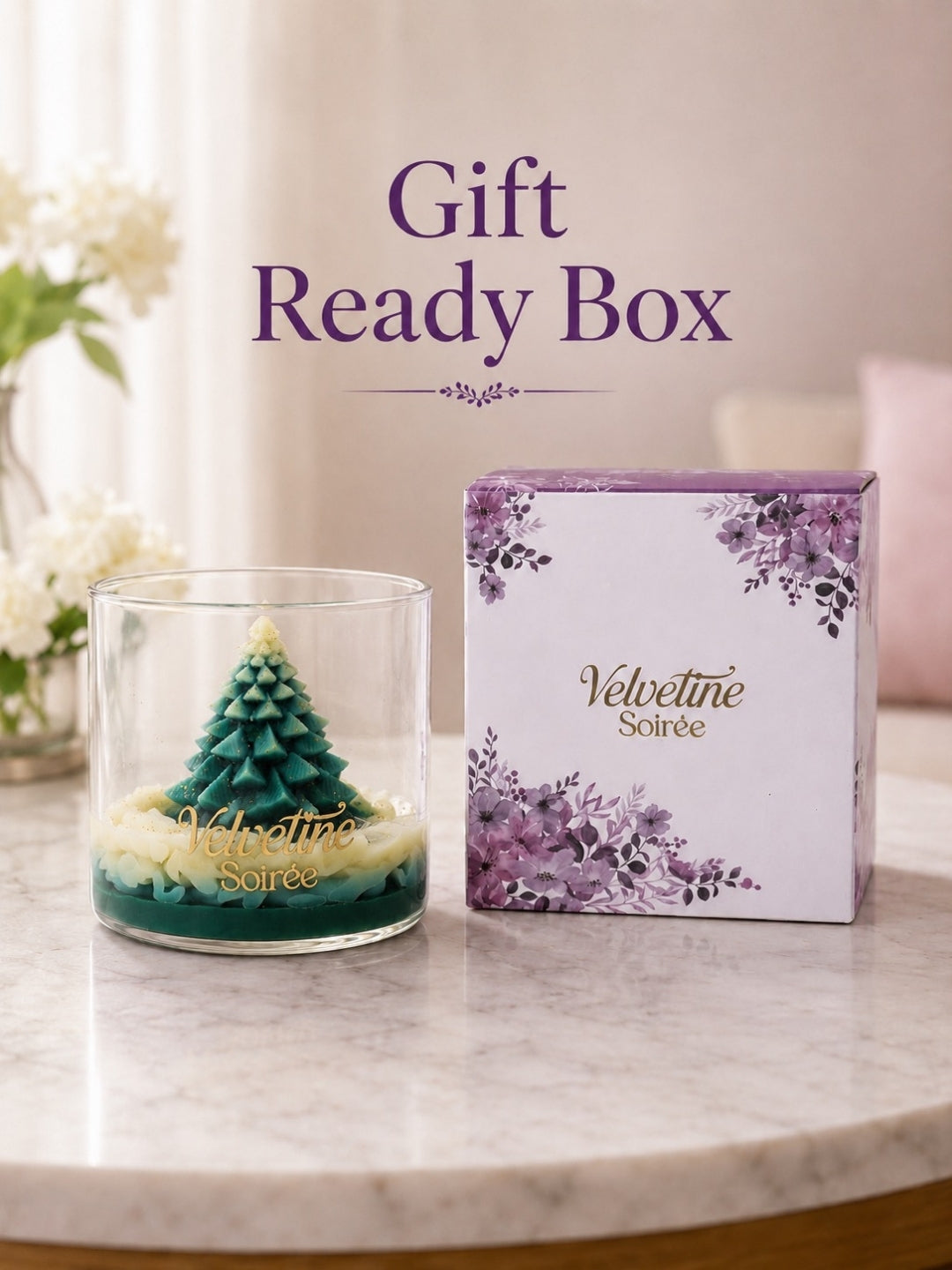A gift-ready candle set on a marble surface with Christmas Morning Candle Jar with evergreen forest fragrance and purple floral box labeled Velvetine Soirée. Large text above reads 'Gift Ready Box'.